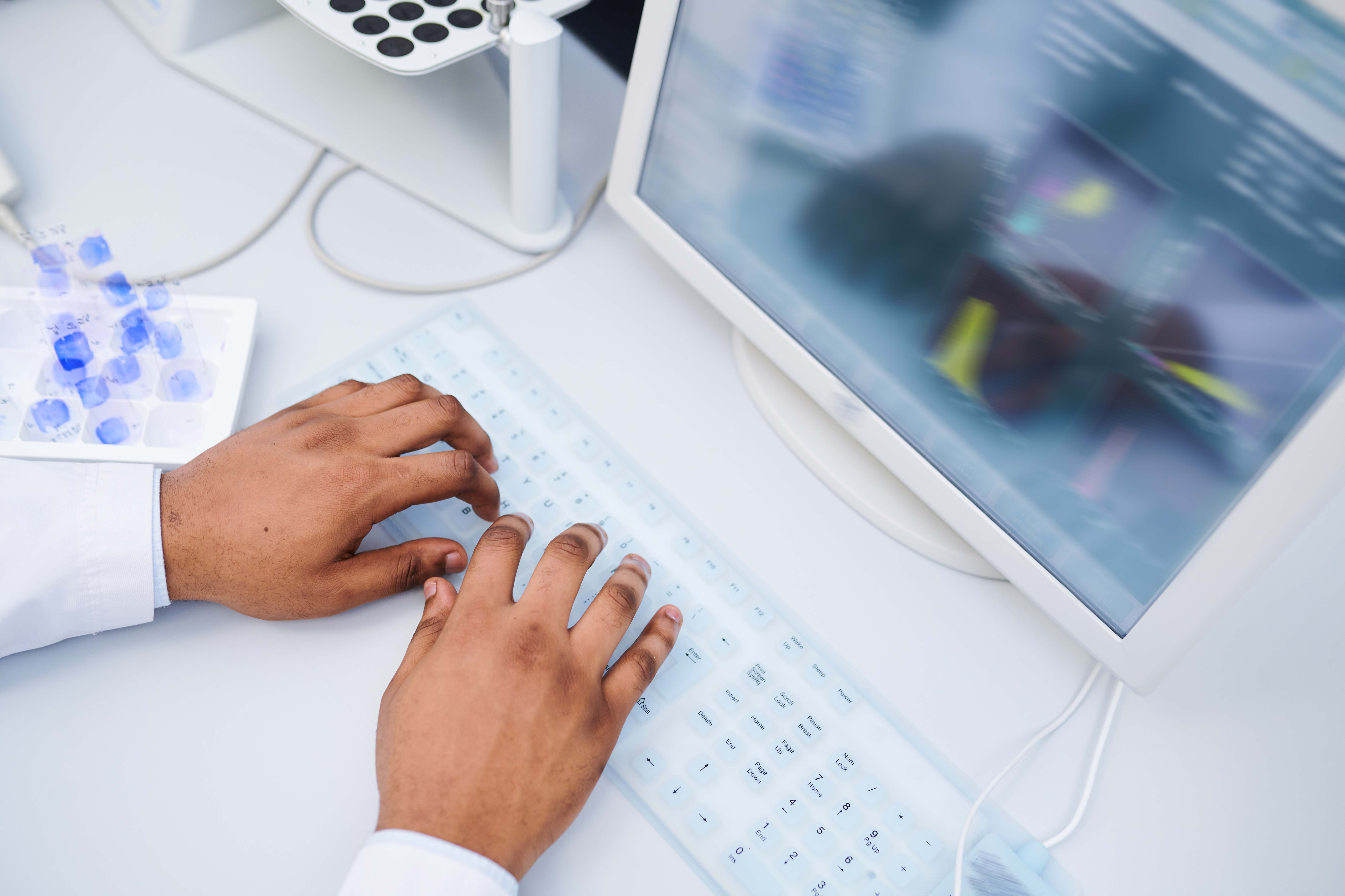 Hands typing results on computer keyboard