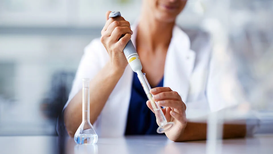 Scientist pipetting sample into test tube