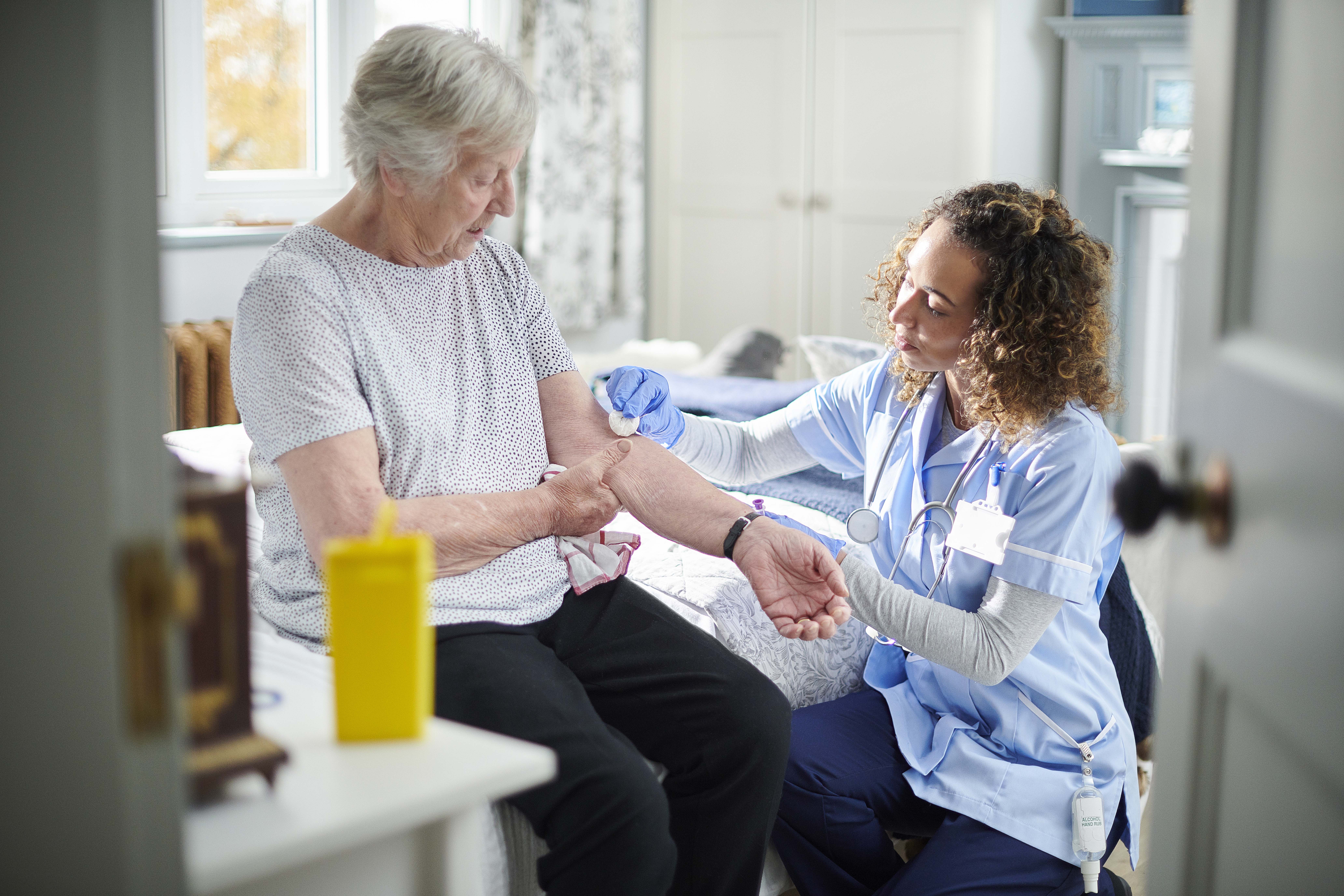 Nurse taking blood from an elderly diabetic patient