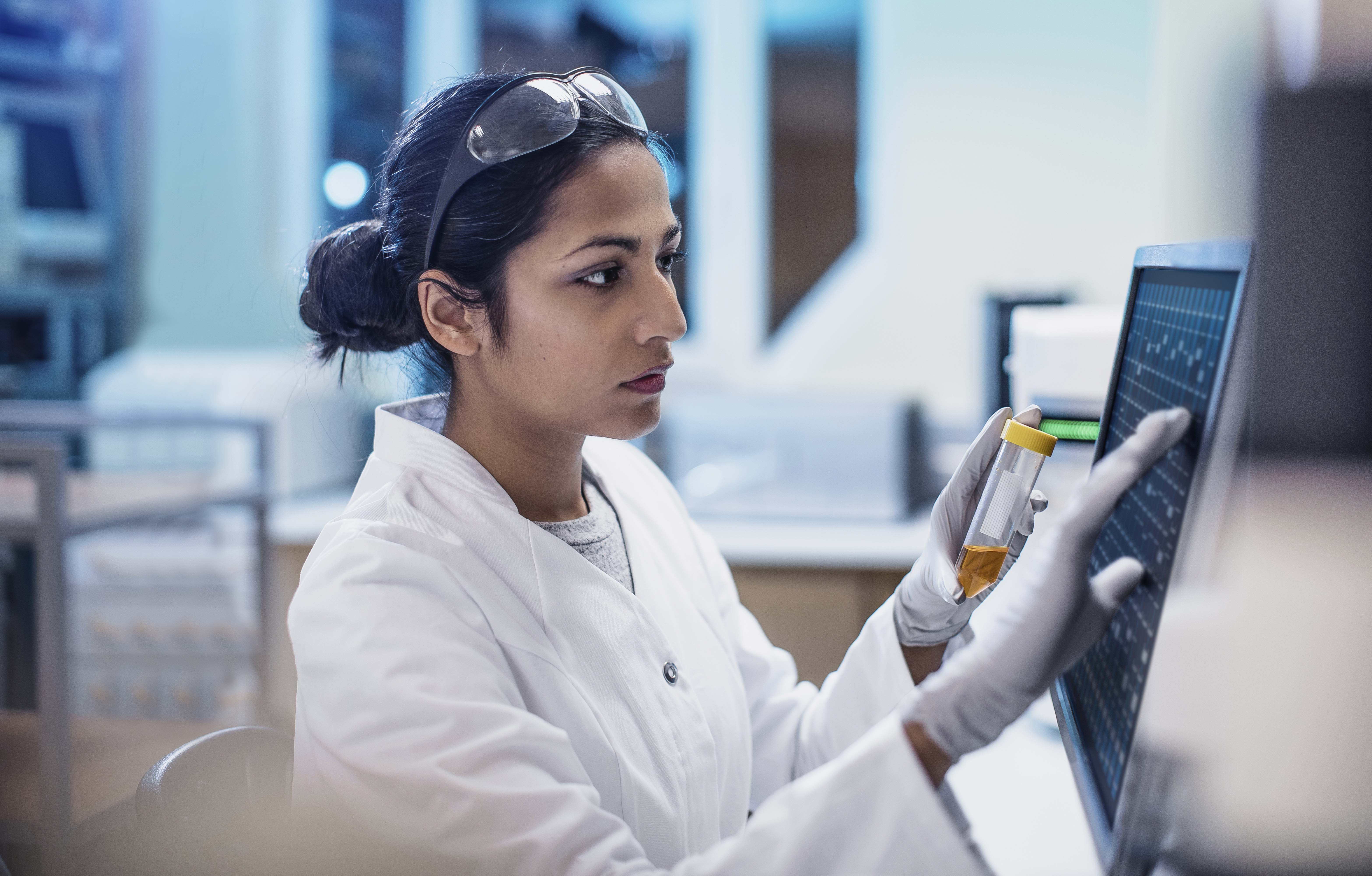 Female scientist working in the lab, using computer screen