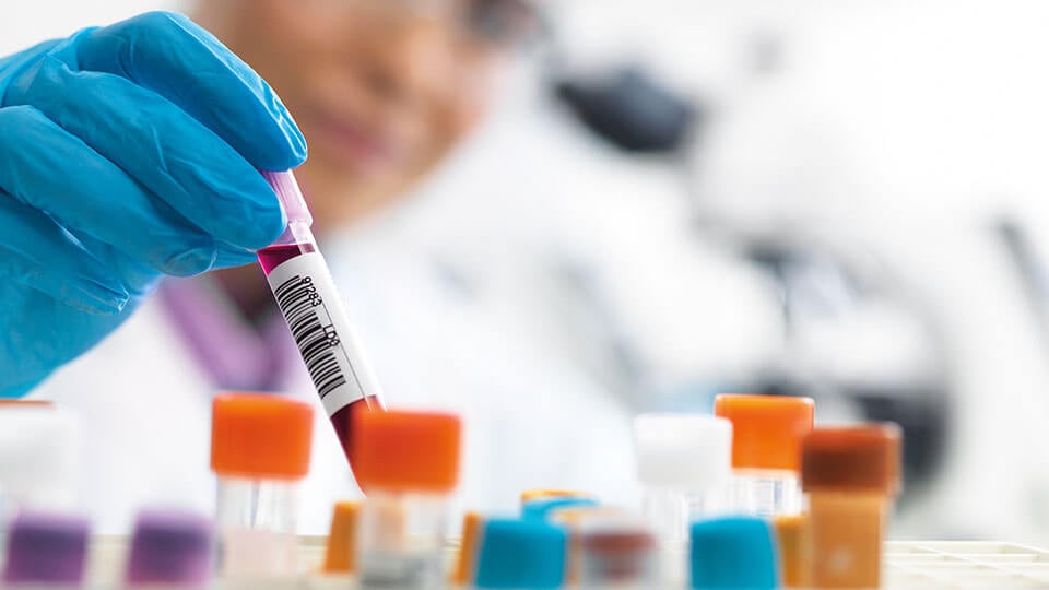 Female scientist about to view a human sample under a microscope