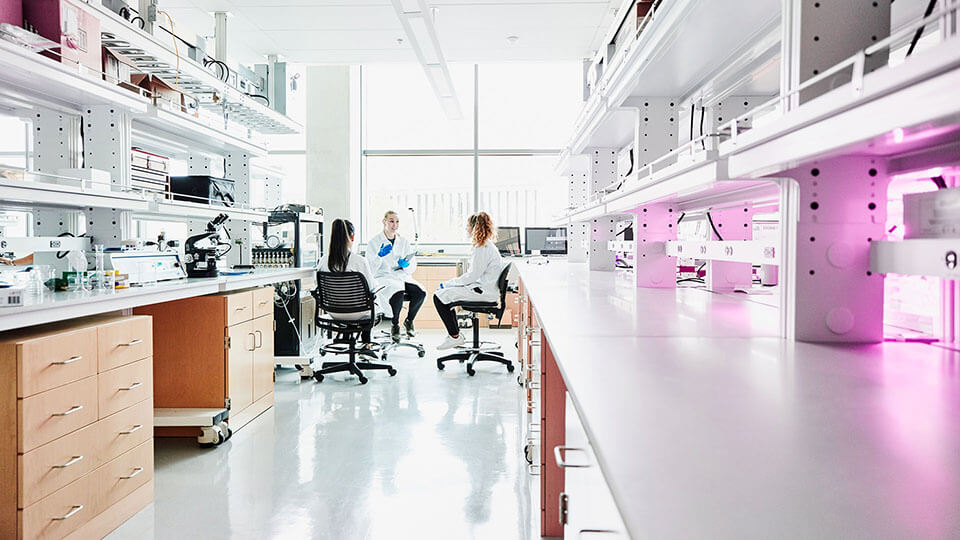 Female scientist leading project discussion with colleagues in laboratory