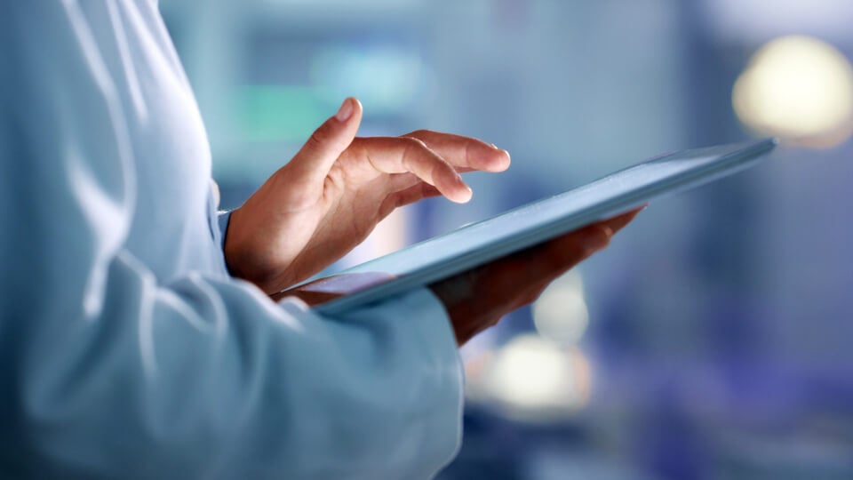 Doctor, researcher or scientist browsing the internet on a tablet for information while working at a lab, science facility or hospital. Expert, medical professional or surgeon searching the internet