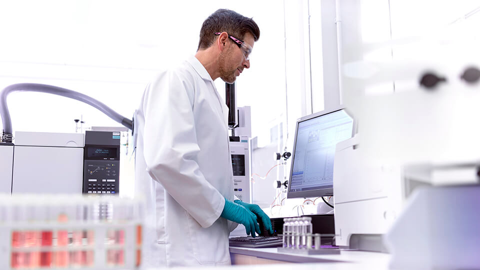 Male scientist at workstation testing samples