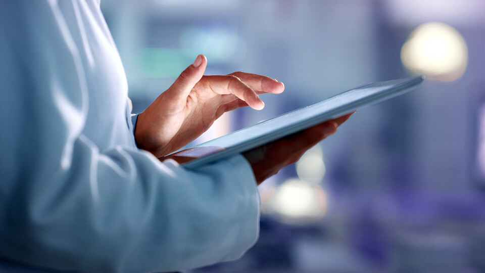 Doctor, researcher or scientist browsing the internet on a tablet for information while working at a lab, science facility or hospital