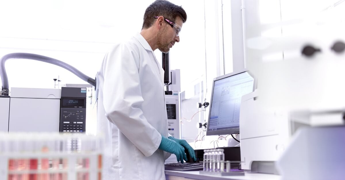 Male scientist at workstation testing samples