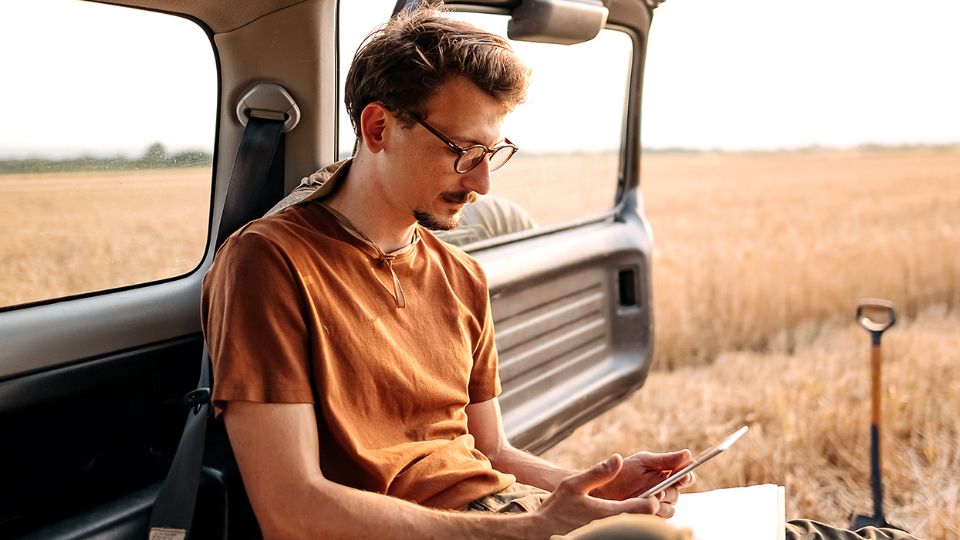 Young farmer collecting data of his field on digital tablet