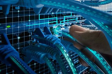 Photo of fingers connecting a CAT5 cable into a plug on a network board or connectivity device for laboratory information management interoperability and communications