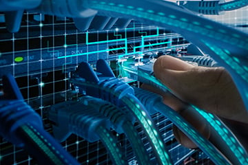 Photo of fingers connecting a CAT5 cable into a plug on a network board or connectivity device for laboratory information management interoperability and communications