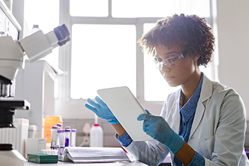 Young female scientist using digital tablet in lab
