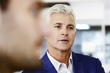 Businessman with colleague writing on whiteboard