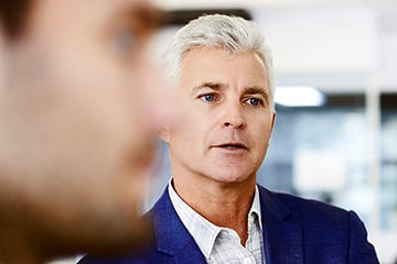 Businessman with colleague writing on whiteboard