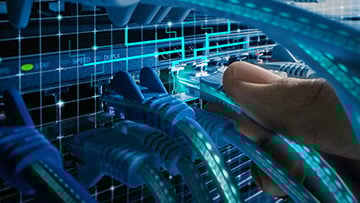 Photo of IT Administrator's fingers connecting an RJ45 Internet connector into LAN router switch with network cables denoting network connectivity and laboratory information management interoperability and communications