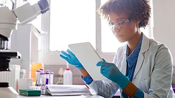 Young female scientist using digital tablet in lab